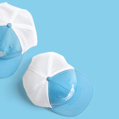 Two custom embroidered hats on a blue background